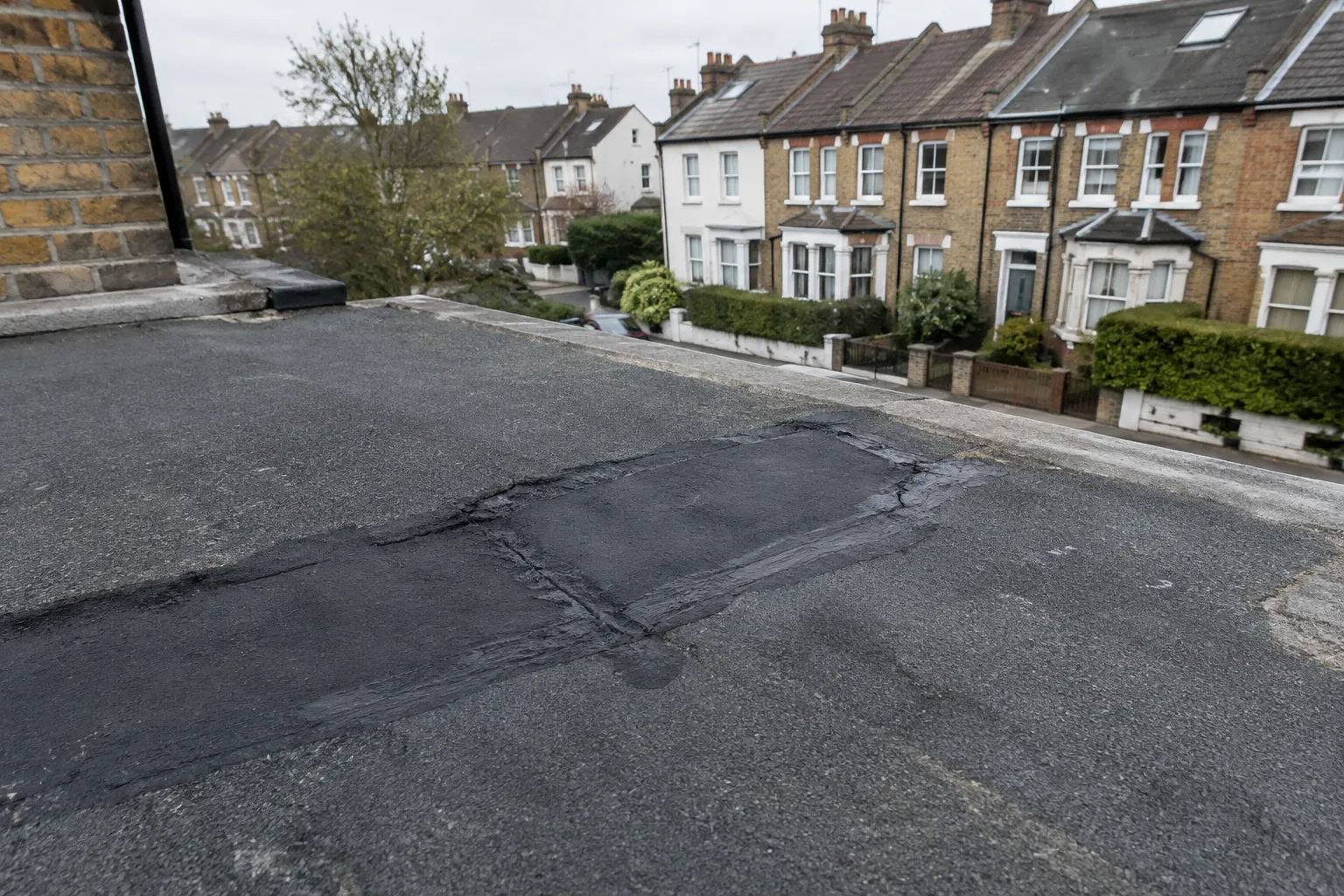 Repair patch applied to a crack on a flat roof